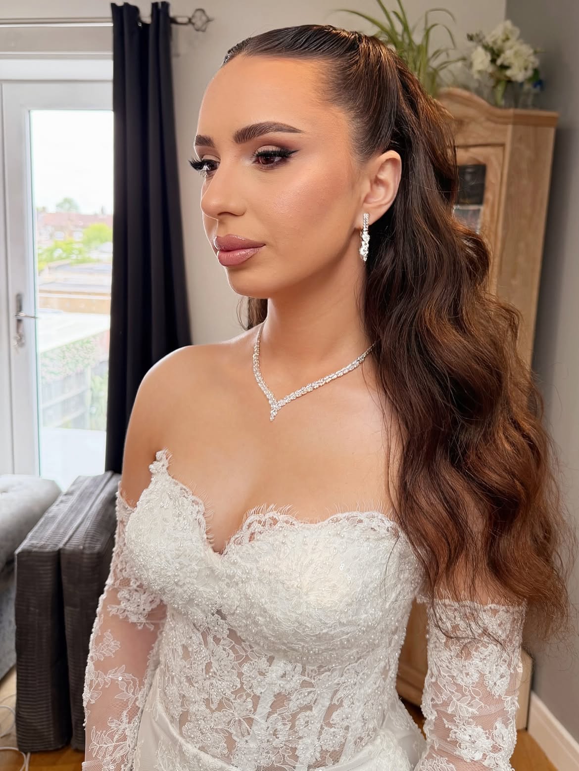Bridal soft glam with a sleek half-up style and long waves