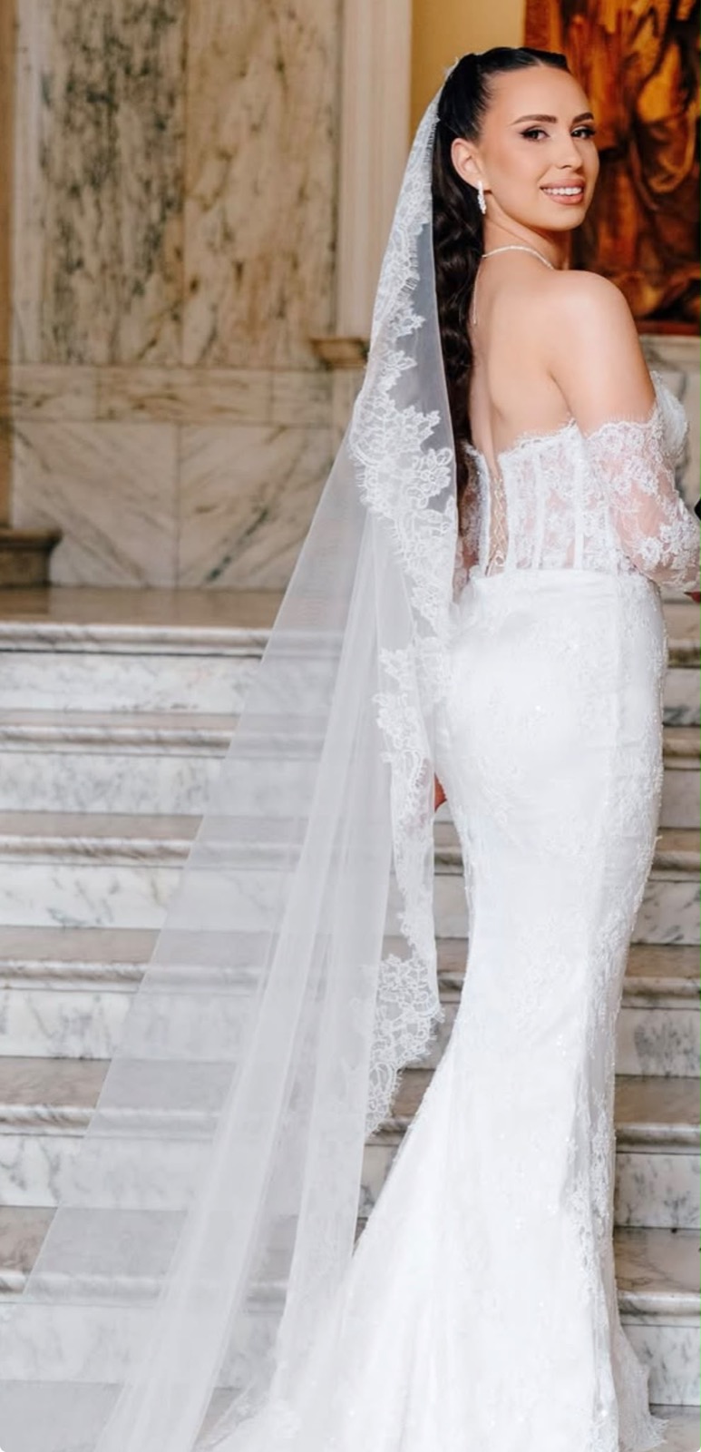 Bride from behind showing a full-length lace cathedral veil