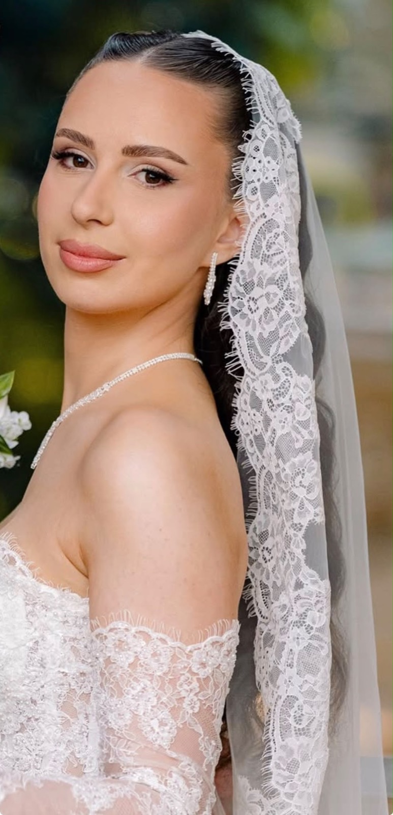 Close-up bridal makeup with a soft flush and a lace veil