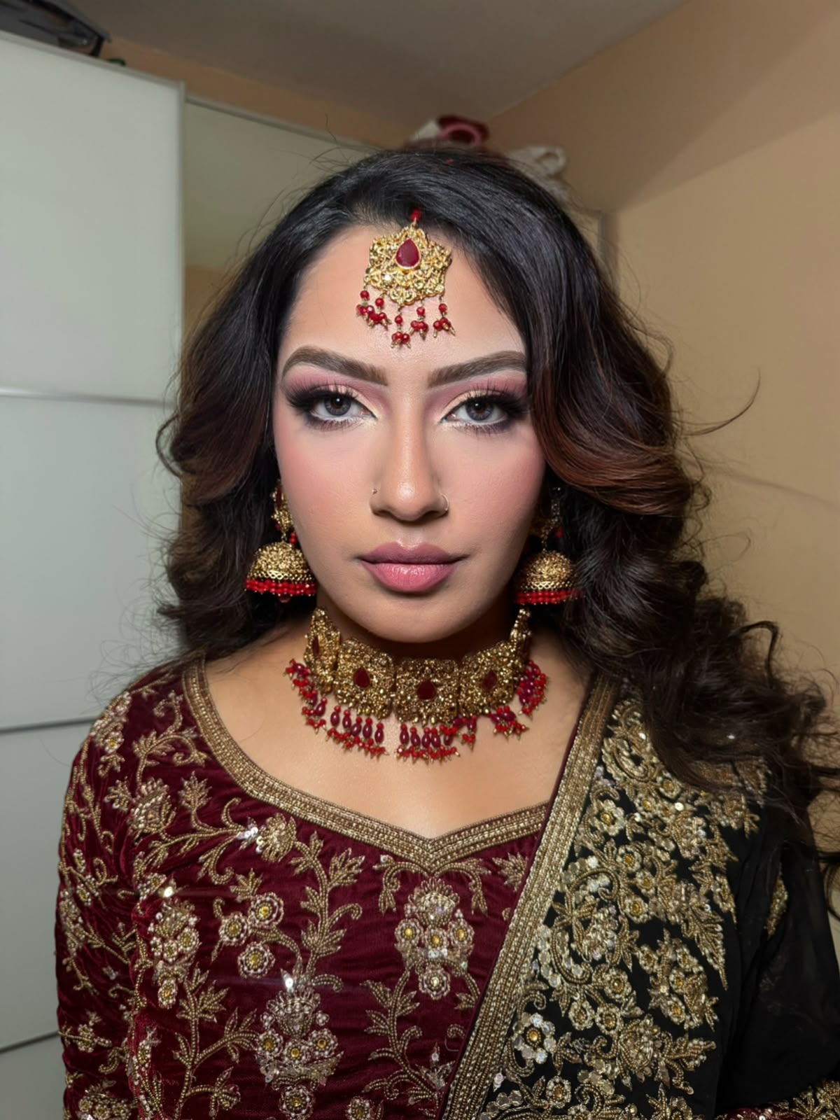 South Asian bridal makeup with traditional gold jewellery and a soft pink eye