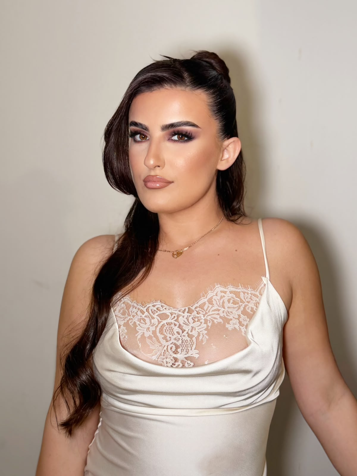 Soft bridal glam with a half-up style and cream satin lace
