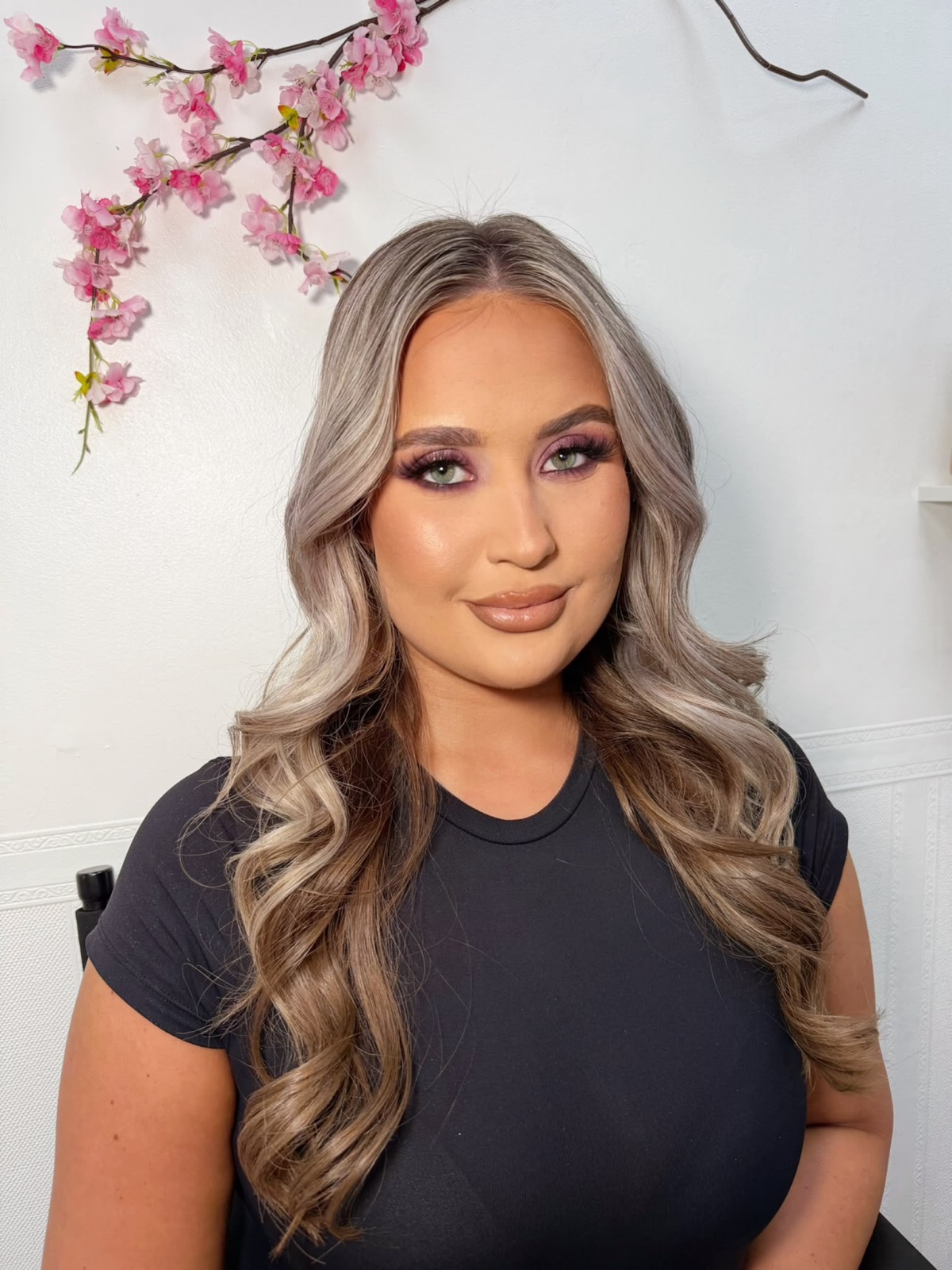 Long curled blonde balayage with a mauve smokey eye