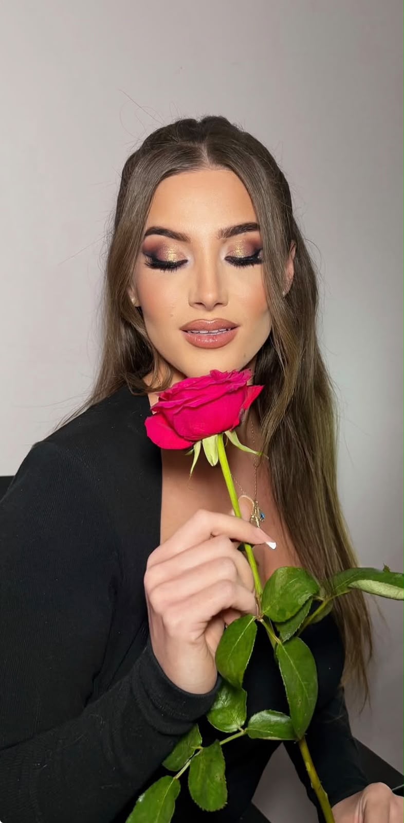 Editorial portrait with a red rose and a bronzed smokey eye