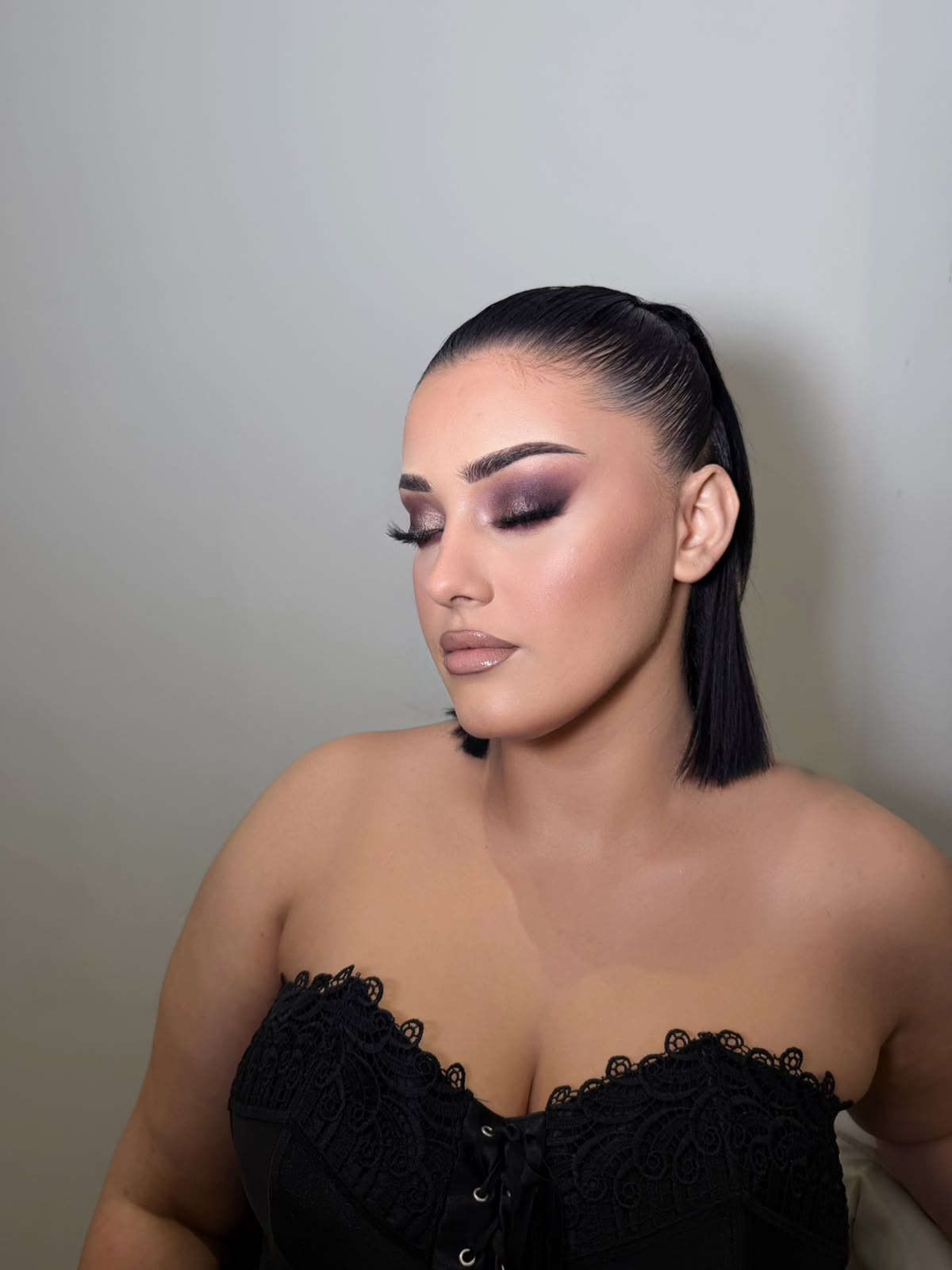 Sleek ponytail with a plum smokey eye and black lace corset