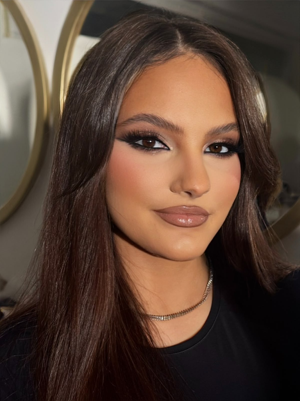 Sleek dark hair with a bronze smokey eye and nude gloss